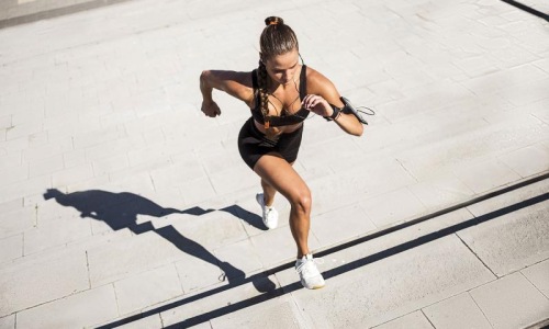 Get your workout on woman exercises running outside up stairs