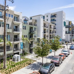 exterior of a building with many windows and cars parked beside it