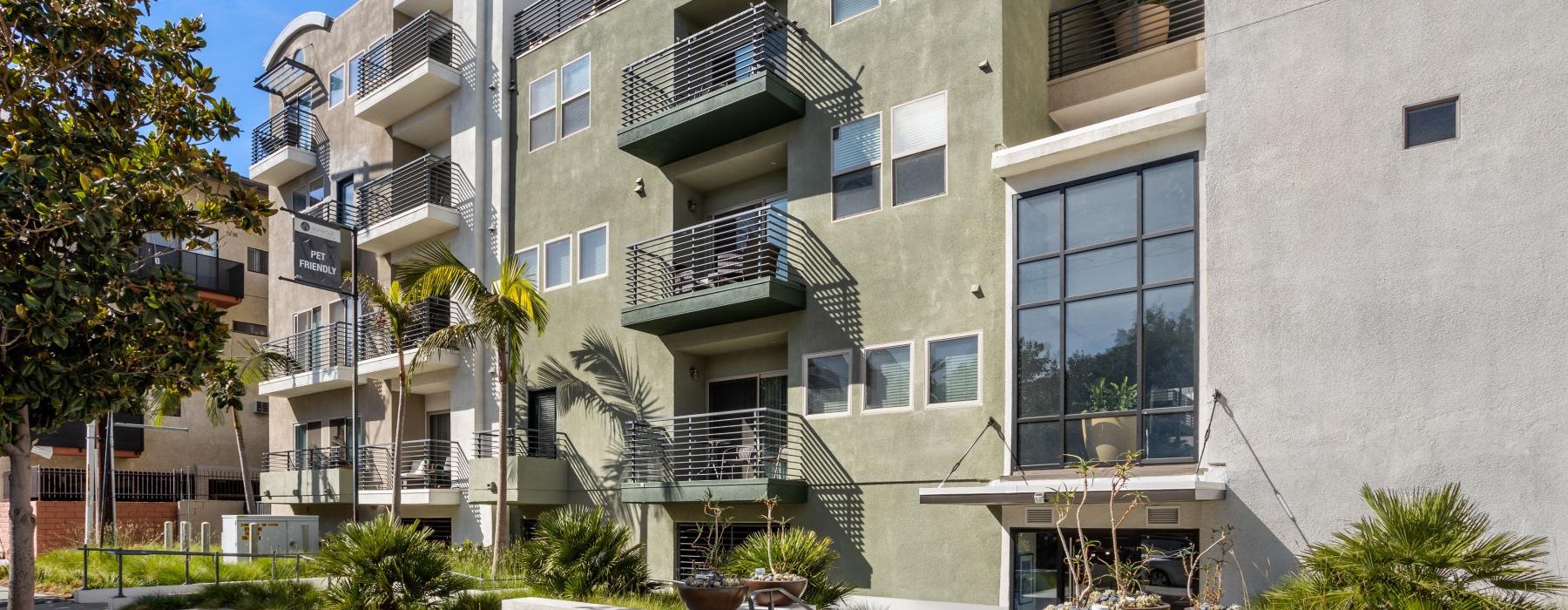 a building with balconies and plants in front of it
