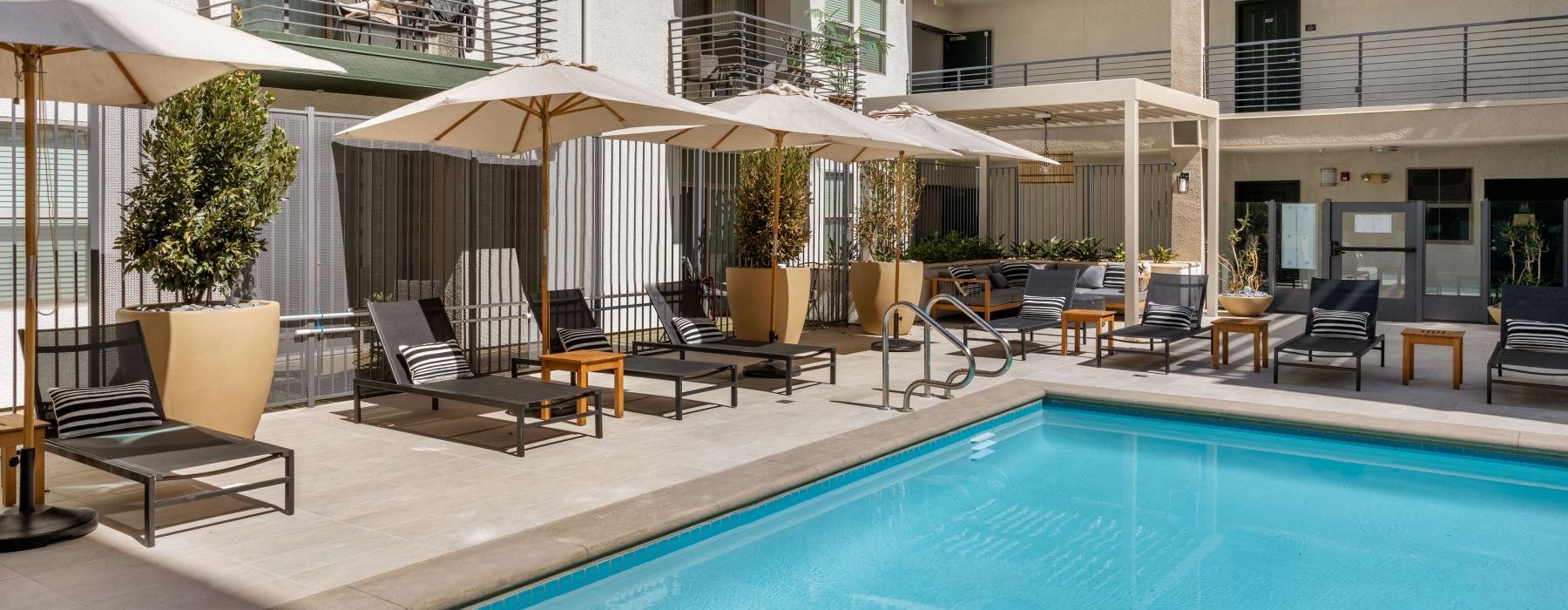 a pool with chairs and umbrellas